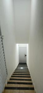 un lungo corridoio con una porta bianca e delle scale di Apê da Lili a Ilha de Boipeba 1 altra foto