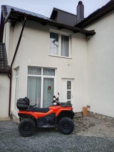a red atv parked in front of a house at Apartament Adelina Borsa in Borşa