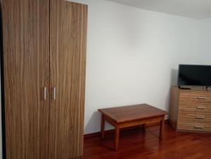 a room with a wooden cabinet and a table at Apartament Adelina Borsa in Borşa
