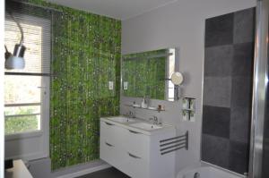 a bathroom with a sink and a mirror at Gîte Le Moirantin in Moirans-en-Montagne