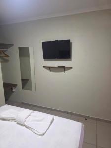 una stanza con un letto e una TV su una parete di Pousada Alvorada a Engenheiro Coelho Altre 2 foto