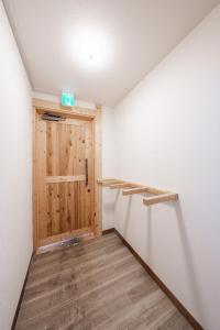 einen Flur mit Holztür in einem Zimmer in der Unterkunft King Deer in Higashikawa