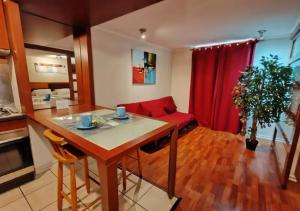 een woonkamer met een tafel en een rode bank bij Apart Merced Home in Santiago