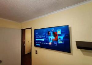 een flatscreen-tv die aan de muur hangt bij Apart Merced Home in Santiago +5 foto's