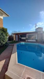 a large blue swimming pool in front of a house at Alquiler temporal Casa céntrica in La Falda