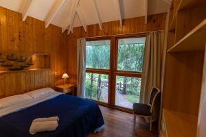 a bedroom with a bed and a large window at Complejo Pelicano Chapadmalal in Chapadmalal