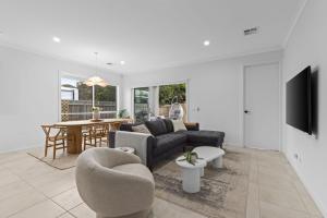 un salon avec un canapé et une table dans l'établissement Luxe Coastal Retreat, à St Leonards