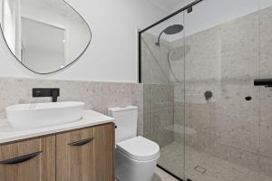 une salle de bains avec toilettes, lavabo et miroir dans l'établissement Luxe Coastal Retreat, à St Leonards 7 autres photos