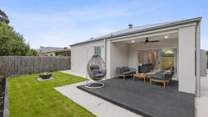 une arrière-cour d'une maison avec une terrasse dans l'établissement Luxe Coastal Retreat, à St Leonards