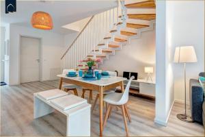 a dining room with a table and a staircase at Ostseenest Bernstein in Kölpinsee