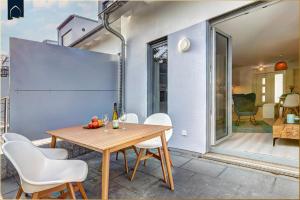 a dining room with a wooden table and white chairs at Ostseenest Bernstein in Kölpinsee +31 photos