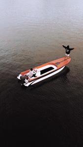 twee mensen staan op een boot in het water bij The Infinity Kintamani With Natural Hot Spring in Kubupenlokan