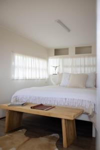 a white bedroom with a large bed and a wooden table at Drovers Run B&B and Events Venue 