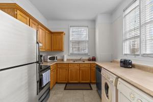 een keuken met houten kasten en een witte koelkast bij Charming 2BR Wi-Fi Off-Street Parking in St. John's +24 foto's