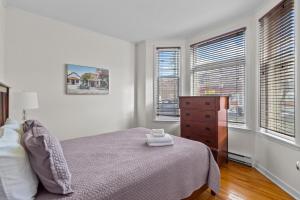 een slaapkamer met een bed, een dressoir en ramen bij Charming 2BR Wi-Fi Off-Street Parking in St. John's