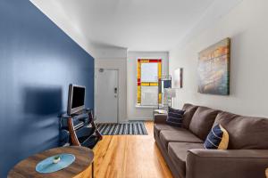 een woonkamer met een bank en een tv bij Charming 2BR Wi-Fi Off-Street Parking in St. John's
