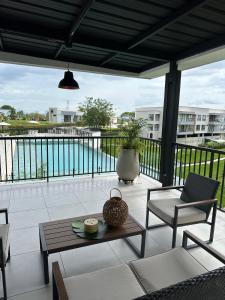a patio with a table and chairs and a view of the water at Apartamento Campestre 6 Pax in Armenia