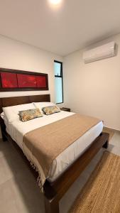 a bedroom with a large bed with two pillows at Apartamento Campestre 6 Pax in Armenia