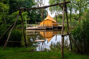 a yurt on a dock in the middle of a pond at ASILI DELUXE - Zebra in Lichtaart +29 photos