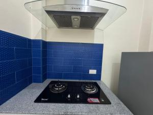 una cucina con piastrelle blu sul muro e piano cottura di Villa88 สันกำแพงสายใหม่ 
