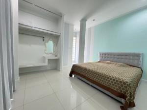 una camera da letto con un letto e uno specchio sul muro di Villa88 สันกำแพงสายใหม่ 