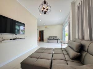 un soggiorno con divano e TV a schermo piatto di Villa88 สันกำแพงสายใหม่ 