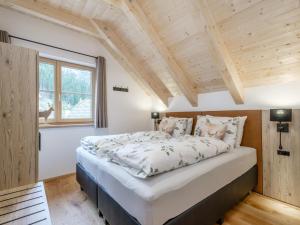 a large bed in a room with a wooden ceiling at Chalet Karibu in Donnersbachwald