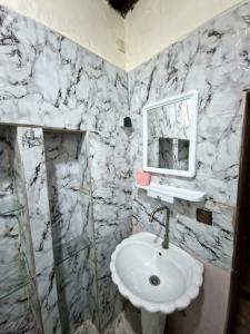 Un baño con un lavabo blanco y un espejo. en Cozy Nest, en Sale 17 fotos más