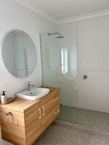 a bathroom with a sink and a mirror and a shower at Spring Haven in Wagga Wagga +5 photos