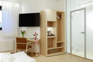 una camera da letto con scrivania e TV di Polar Nook Hotel a Rovaniemi Altre 22 foto