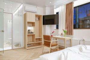 una camera da letto con un letto, una scrivania e una TV di Polar Nook Hotel a Rovaniemi