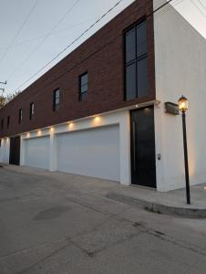 un edificio in mattoni con un garage e un parcheggio di Lina Élite Suites a Chihuahua