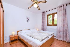 a bedroom with a bed and a ceiling fan at Apartments with a parking space Mali Losinj (Losinj) - 376 in Mali Lošinj