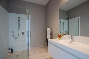 een badkamer met een glazen douche en een wastafel bij Bishop's Lane in Sandspit +27 foto's