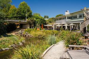 een loopbrug naast een rivier met een brug bij Bishop's Lane in Sandspit