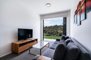 een woonkamer met een bank en een flatscreen-tv bij Bishop's Lane in Sandspit