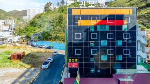 a building with a painting on it next to a road at Geoje Queen Motel in Geoje