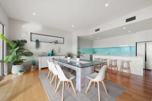 een keuken met een eettafel en witte stoelen bij The Bluff Villa 4-121 Franklin Pde Encounter Bay - Linen Included in Encounter Bay