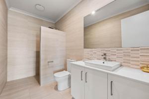 een badkamer met een witte wastafel en een toilet bij The Bluff Villa 4-121 Franklin Pde Encounter Bay - Linen Included in Encounter Bay