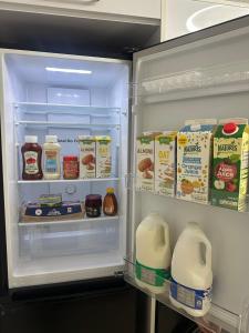 an open refrigerator filled with milk and eggs at AMD Hotel Wallington SM6 in Wallington