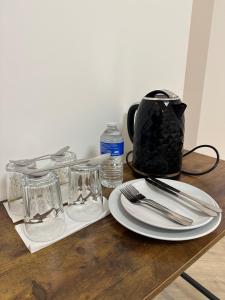 a wooden table with a plate and glasses on it at AMD Hotel Wallington SM6 in Wallington +38 photos