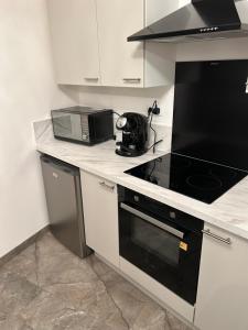 a kitchen with a stove top oven and a microwave at Maison Relax Spa & tranquillité in Auberchicourt +7 photos