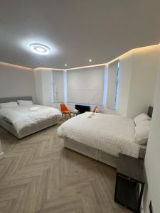 een slaapkamer met twee bedden en een houten vloer bij AMD Hotel Wallington SM6 in Wallington +38 foto's