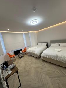 a bedroom with two beds and a table and chairs at AMD Hotel Wallington SM6 in Wallington