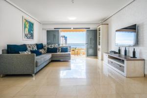 un soggiorno con un divano e una televisione di Magnífico Sol Paraíso ad Adeje