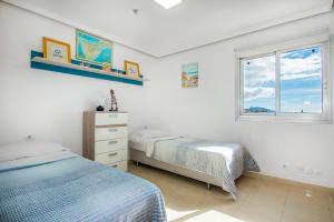 una camera da letto con due letti e una finestra di Magnífico Sol Paraíso ad Adeje Altre 29 foto