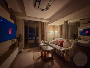 een woonkamer met een bank en een flatscreen-tv bij Abby Sky&Seaview Staycation Cebu in Mandaue-stad