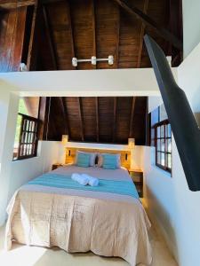 a bedroom with a bed with two towels on it at Studio Na Natureza Com Hidro - Baoba Suites in Bombinhas +16 photos
