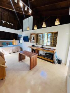 a room with a desk and a bed and a table at Studio Na Natureza Com Hidro - Baoba Suites in Bombinhas