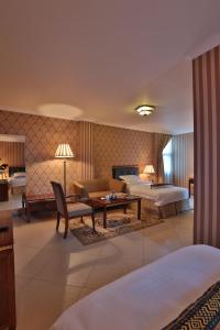 ein Hotelzimmer mit zwei Betten und einem Tisch in der Unterkunft The Residence Hotel in Addis Abeba